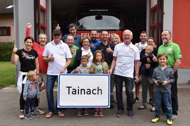 Die Freude über den zweiten Sieg ist groß: Dorfbewohner mit Gemeinschaft Tainach Obmann Martin Urak (vorne re.) vor dem Rüsthaus