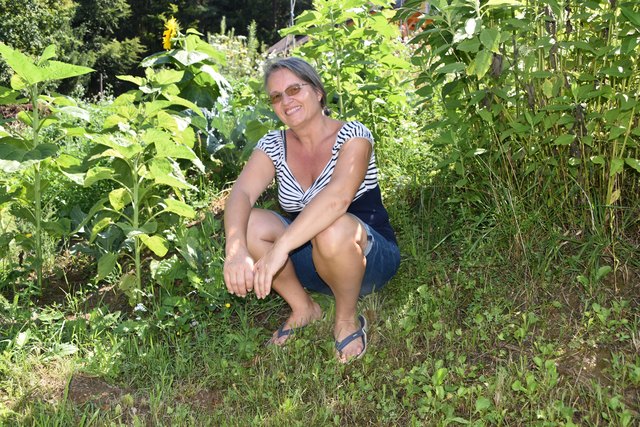 Maria Ramšak zwischen Sonnenblumen in ihrem Permakulturgarten in St. Peter am Wallersberg