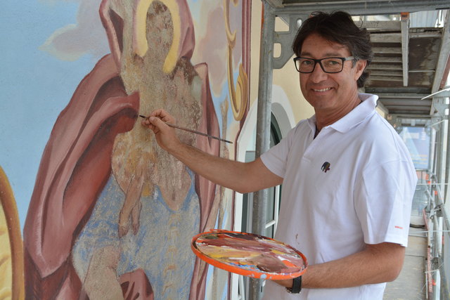 Martin Juen aus Rietz frischt das verblasste Fresko des Hl. Christophorus mit Jesuskind auf.