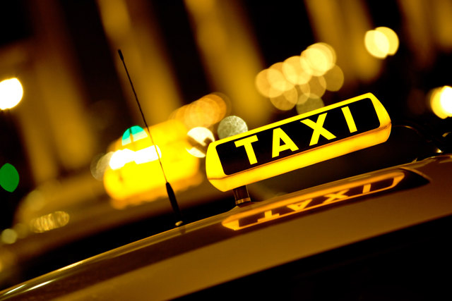 Taxi cab at night with the sign lit 