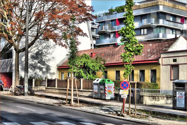 Auch in der querenden Straße werden die ebenerdigen Häuser schon sehr vom modernen Wohnbau bedrängt