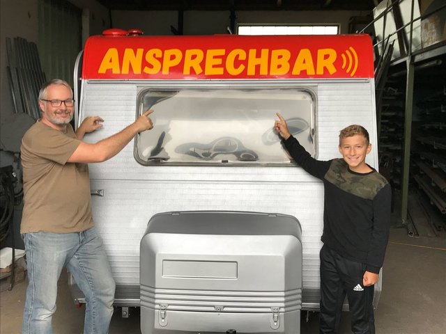 Markus Ellerböck und Jakob Wimmer (rechts) haben beim Einrichten der "Ansprech-Bar" geholfen. Der Wagen steht am 15. September 2018 beim Weinlesefest in Blümling. | Foto: Haunold