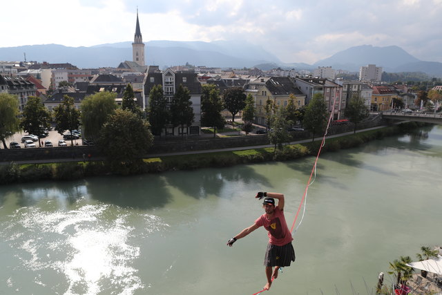 Alex Schulz auf der Slackline hoch über der Drau in Villach. | Foto: Kletterhalle Villach