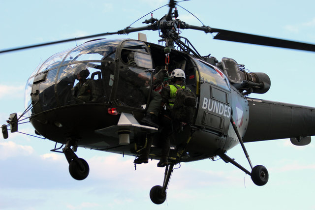Ein Flugretter wird zum abgestürzten Piloten abgeseilt.