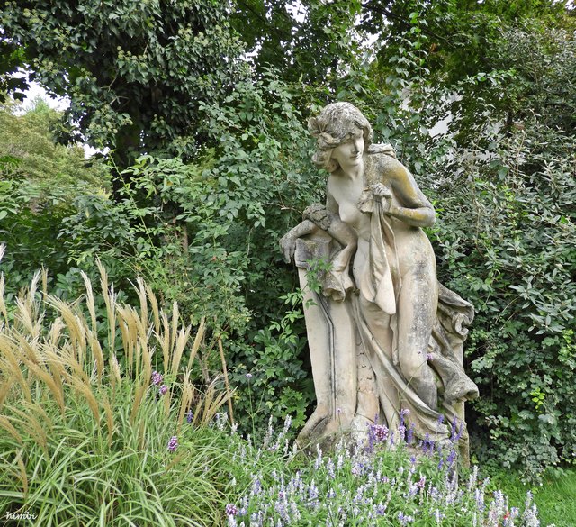 Statue Nackte Frau an Steinpfeiler gelehnt