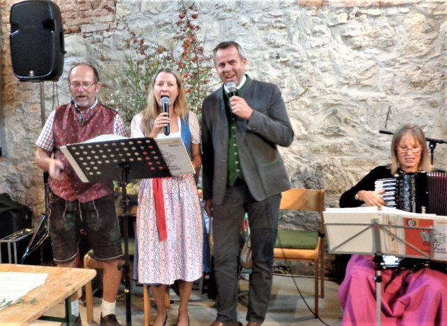 Viechtwang: Der Bürgermeister LAbg. Rudolf Raffelsberger ( rechts) der Kapellmeister Florian Kammerstätter von der Gerstl Musi (links) und eine Sängerin ( Mitte ) hatten mit weiteren Musikern der Gerstl Musi mit dem Gesang für beste Stimmung gesorgt. Foto: Bamer Friedrich.