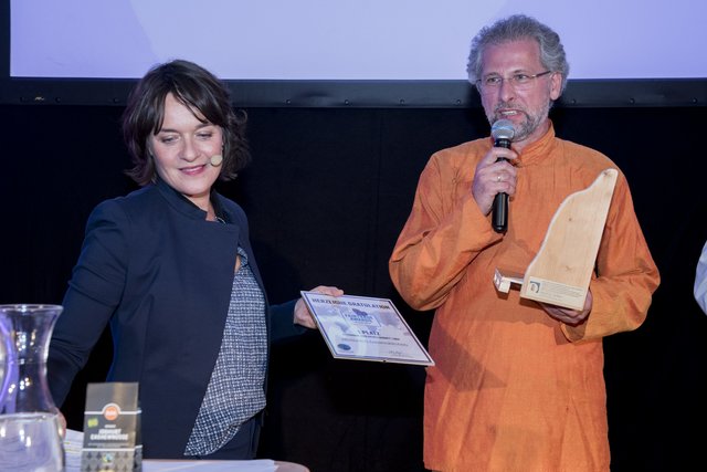 Weltladen-GF Christian Zettl erhält den FAIRTRADE Award 2018 von Moderatorin Eva Pölzl.