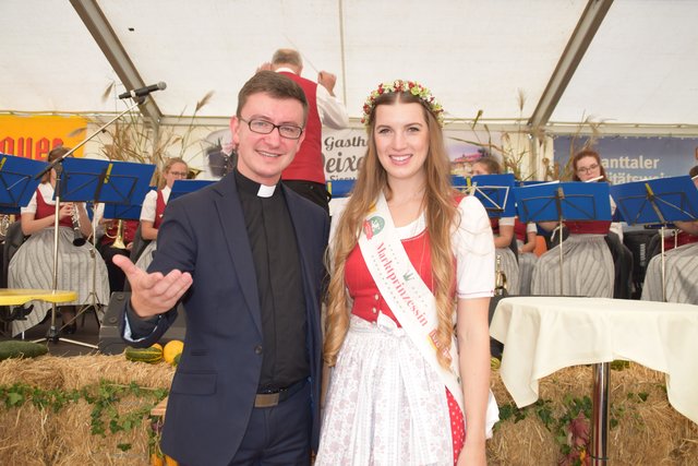 Kaplan Krzysztof Kranicki mit Marktprinzessin Sandra Ragger (im Hintergrund die Ortsmusik Maria Trost)