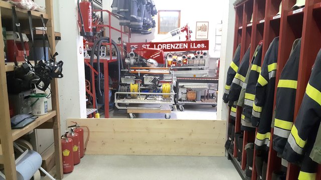Ein Brett soll Gerätschaften der Feuerwehr vor dem Wasser schützen, behindert aber bei Einsätzen