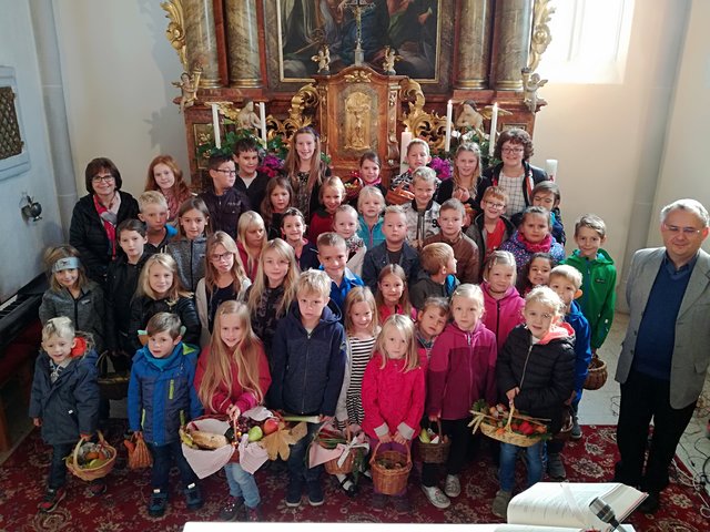 Lehrerin Brunhilde Berger, Religionslehrerin Christa Müllauer, Pfarrer Andreas Sliwa sowie die Kinder mit ihren Erntegaben.