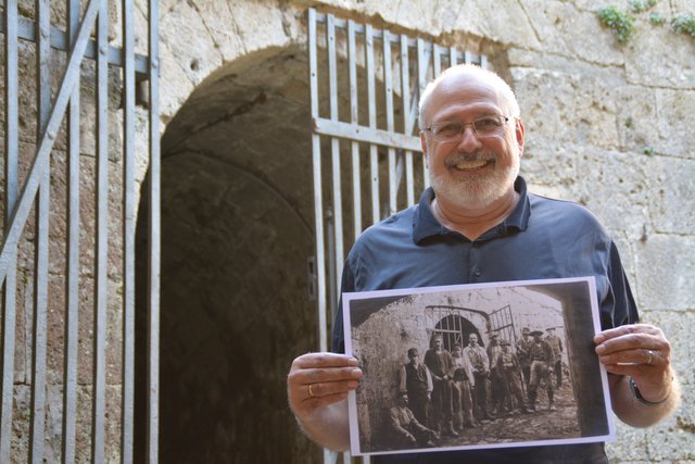 Dietmar Wieser mit einer Fotografie, die serbische Kriegsgefangene auf der Kufsteiner Festung zeigt, am selben Ort, wo die historische Aufnahme entstand.