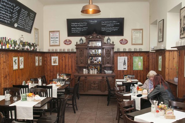 Originelles Wiener Wirtshaus: Alte restaurierte Möbelstücke zieren den Gastraum, eine alte, verglaste Wand trennt Schank- und Speiseraum.
