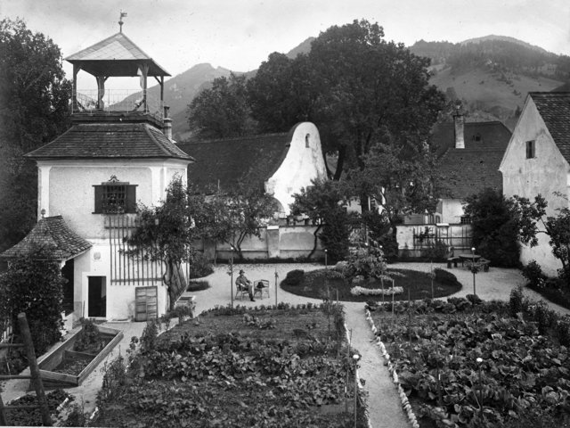 Garten der Familie Ransmeier in Micheldorf (heute steht dort das Haus der Familie Schmiedinger), im Hintergrund das ehemalige Sensenwerk an der Zinne. Ramsmeier Micheldorf Garten mit Turm - gehörig zu Sensenwerk an der Zinne (Weinmeister) als Sensenwerk aufgelassen zwischen 1900 und 1907 im Vordergrund der Garten mit Gartenhaus/Salettl (datiert 1803), später Fam. Ransmeier/Ramsmeier(?)