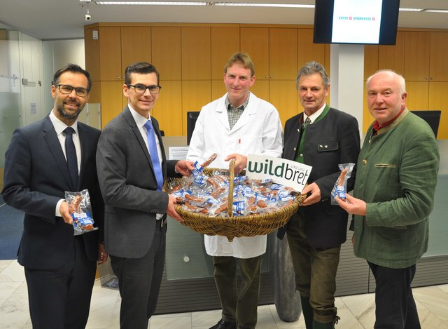 Gerald Baumgartner, links, und Direktor Martin Sutter von der Sparkasse Neuhofen übernehmen die regionale Rehwurst von der ARGE Wildbret Linz Land.