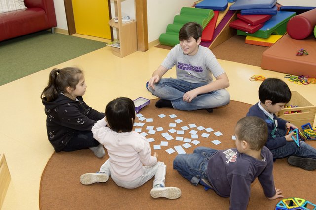 Ein Junge schnuppert als Kindergärtner beim Boys' Day.