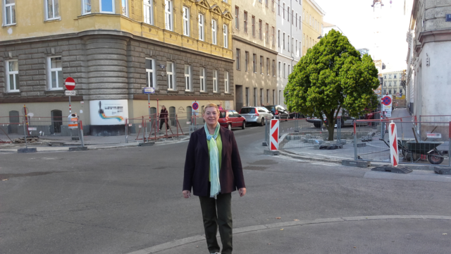 Bezirksvorsteherin Uschi Lichtenegger bei der Baustelle gegenüber des Volkertmarkts. Der Baum wurde grafisch eingefügt.