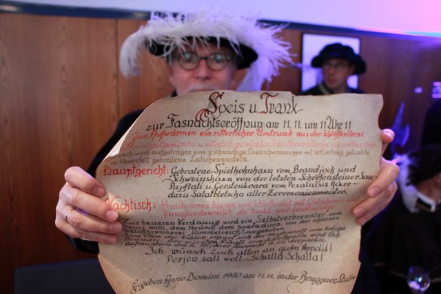 Ehrenritter und Künstler Elmar Peintner hält das Schriftstück mit dem Rittermahl zur Fasnacht 1981 hoch, gekocht von Walter Altmann im Tirolerhof 