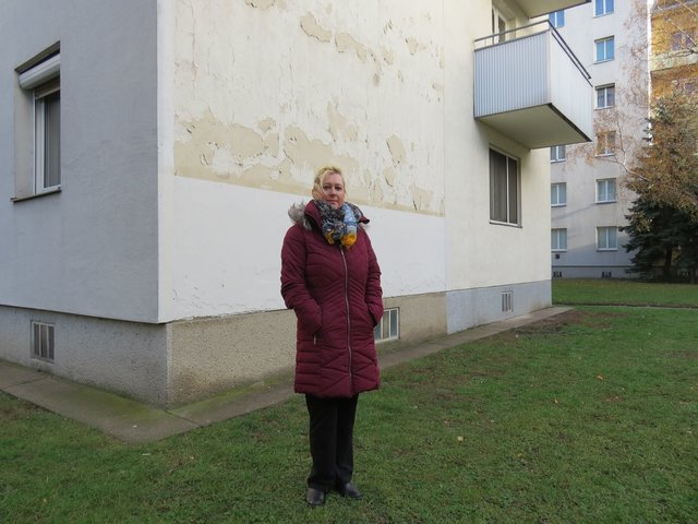 Edyta W. vor der unsanierten Hausmauer, die für die Schimmelbildung im Schlafzimmer verantwortlich zu sein scheint.