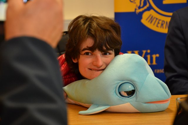Janine sieht den Stoffdelphin und beginnt freudig zu lachen