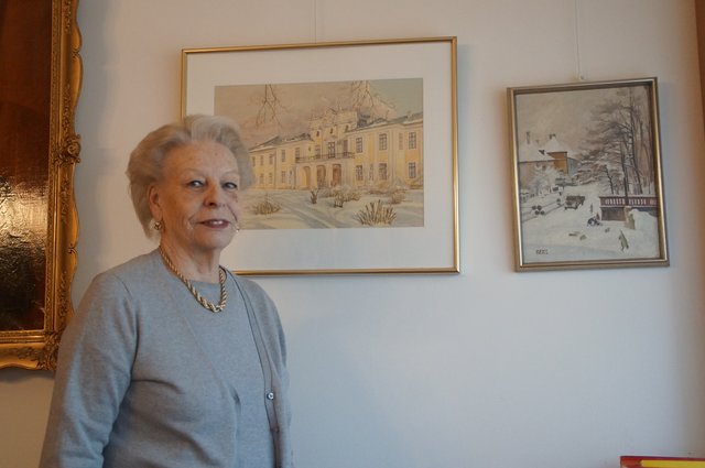 Vladimira Bousska vor einem Bild vom Schloss Hetzendorf im Winter.