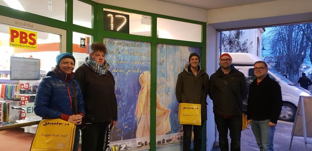 Stimmungsvolles Adventfenster bei "Federführend Papier- & Bürobedarf": Das Team des Jugendzentrums und Streetwork Hartberg, um Teamleiterin Nicole Hartinger (l.) mit Jugendlichen und Stefan Schwinzhakl (r.).