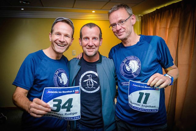 Alexander Rüdiger und Günter Engelhart mit dem 'Antarctic Ice Marathon'-Veranstalter Richard Donovan bei der Startnummernausgabe.