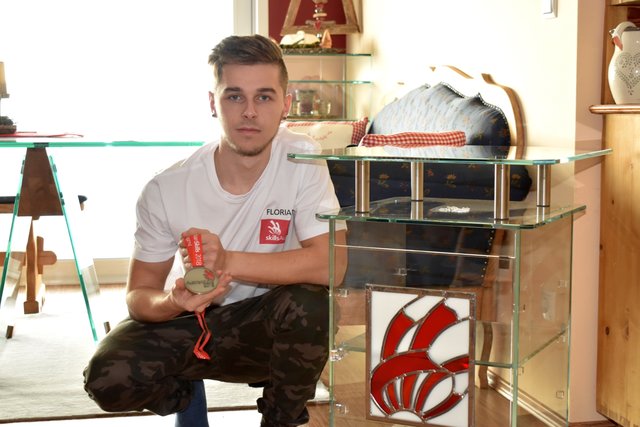 Florian Oswald mit seiner Silbermedaille und seinem Werkstück von den AustrianSkills – das steht bei ihm im Wohnzimmer. | Foto: Michl