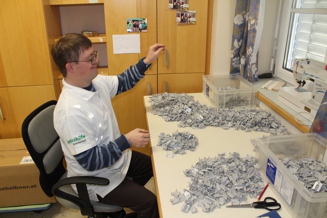 Michael Penzinger beim Sortieren. Stolz zeigt er, was er bei seiner Arbeit zu tun hat. | Foto: Michelle Bichler