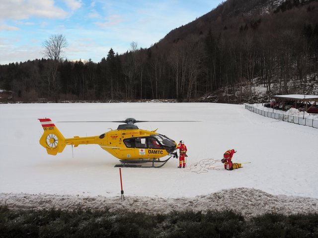 Blitzschnelle Vorbereitung des Rettungsteams zum Abheben auf der Wiese in Fürstenbrunn, um den Verletzten von der Skiabfahrt vom Untersberg zu bergen.