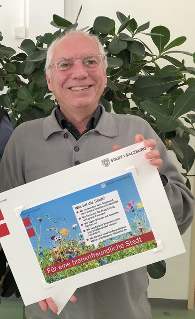 ´Christian Reisinger mit dem Hinweisschild der Stadt zum 10-Punkte-Aktionsplan.