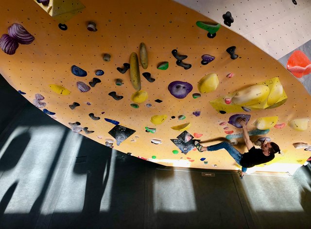 Ein Boulderer versucht sich in der Boulderbar am Wienerberg an einer schweren Route.