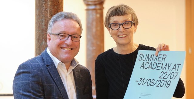 Heinrich Schellhorn und Hildegund Amanshauser mit dem Plakat der Sommerakademie. | Foto: Land Salzburg/Franz Neumayr