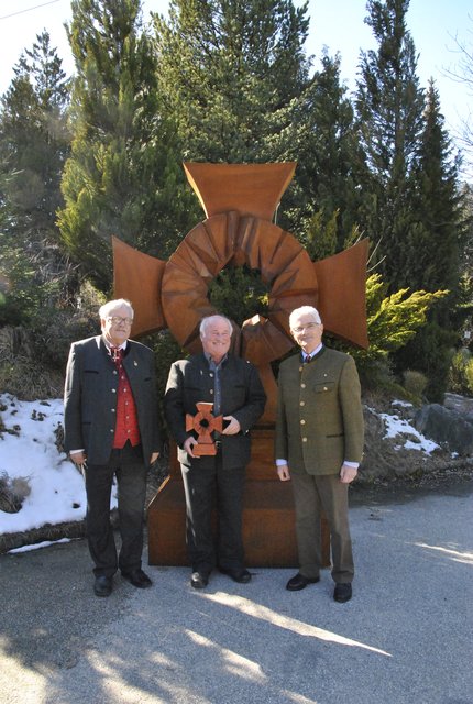 Hermann Hotter, Landesgeschäftsführer Schwarzes Kreuz Tirol, Sagzahnschmied Hans Guggenberger mit dem Holzmodell und Dieter Allesch, Landesgeschäftsführer im Schwarzen Kreuz Steiermark (v.l.).