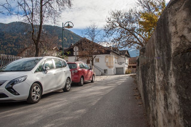 Bild 65: Durchsicht Herzog- Friedrich- Straße von Norden nach Süden (von Haus Nr. 37 zum Haus Nr. 33) zum Dorfplatz. Links hinter der Einfriedung bei den parkenden PKW`s befindet sich die Thingstätte, welche heute als Parkplatz genutzt wird.  | Foto: © by Ing. Günter Kramarcsik