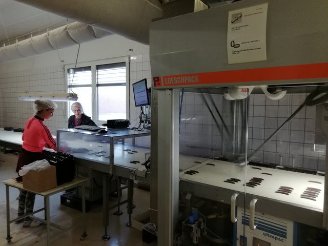 Hier sieht man genauer, dass die Maschine zwar wahnsinnig schnell ist, aber doch nicht alle Schokobananen verpacken kann und man ihr doch etwas zu Hand gehen muss.  | Foto: Werner Achs