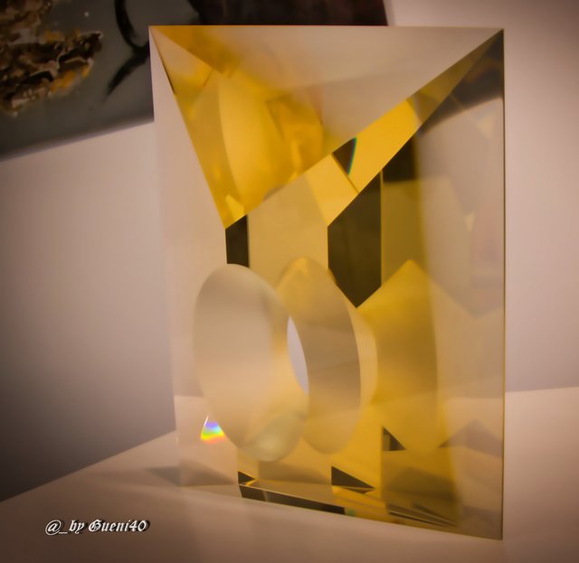 ......das ist so eine Farbenspiegelung,wenn man davor steht,ist es weiß,geht man etwas auf die Seite,andere Winkel kommen diese Farben rein ins Glas,echt faszinierend....