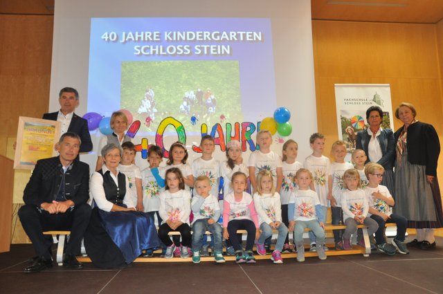 Direktorin Rudolfine Praßl (3.v.l.), Josefine Fasching-Götz (4.v.l.) und Daniela Kreiner (2.v.r.) mit den Kindergartenkindern und Ehrengästen.