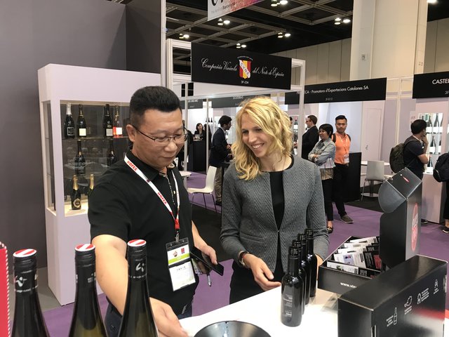 Katja Diewald strahlt bei der Veranstaltung in Hongkong und präsentiert stolz ihre Produkte.