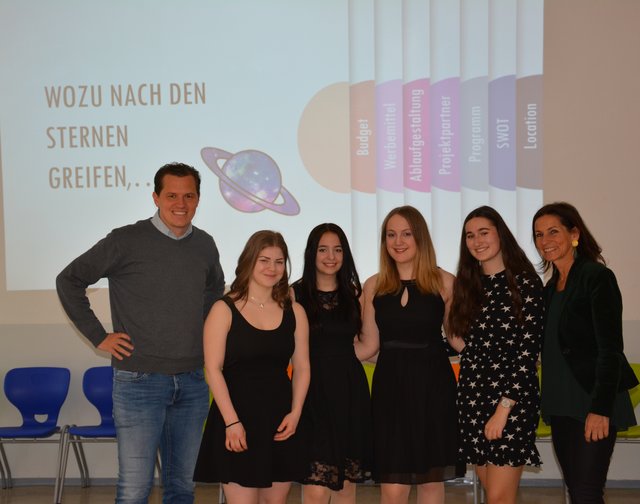 Präsentierten vor Johannes Schreiner vom WIFI Steiermark (links) und Mag. Sabine Jedlicka (rechts) ihr Projekt "Galaktischer Abend": Jennifer Kern, Julia Morgenbesser, Lisa Spreitzhofer und Chiara Lechner.