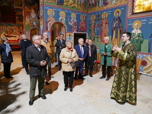 Nemanja Micic (r.) erklärt Mitgliedern von Pro Oriente und Gläubigen der Pfarre St. Severin die Fresken der Kirche.