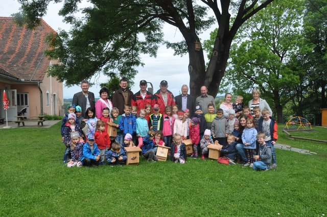 Die Kinder des Stradener Kindergartens mit den Projektverantwortlichen, Ehrengästen und den gestalteten Fledermauskästen.