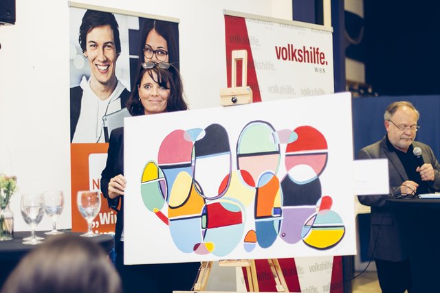 Jobfabrik Volkshilfe Wien: Kunsttherapeutin Heidi Primus mit dem Bild "Ein Team", das mehrere Jugendliche gemeinsam gemalt haben.