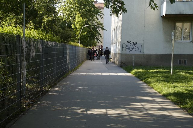 Im Durchgang spielen Kinder neben Radfahrern.
