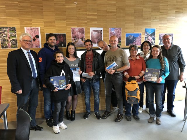 Erfolgreicher Fotowettbewerb in Zams: Bgm. Siegmund Geiger (li.), GR Christoph Wolf (v.l.) und Vizebgm. Josef Reheis (re.) gratulierten dem Sieger Martin Deisenberger (5.v.re) und den erfolgreichen TeilnehmerInnen.