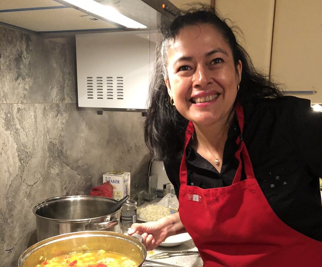 Mónica Ladinig mit dem Kochtopf, in dem das Huhn kocht.