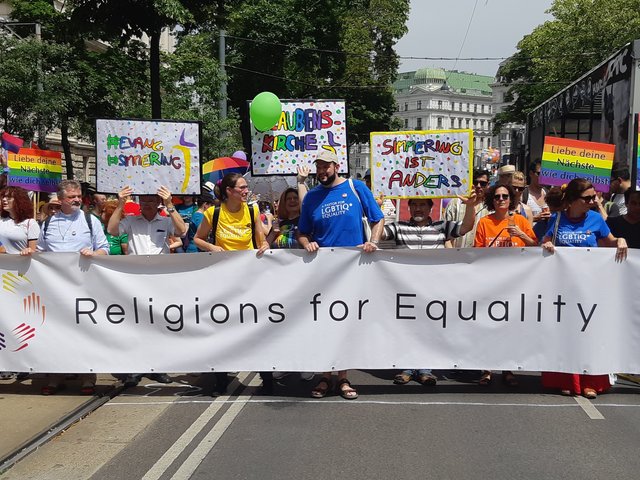 Es geht los: Abmarsch für den Zug "Religions for Equality" - und die Transparente der Glaubenskirche sind nicht zu übersehen