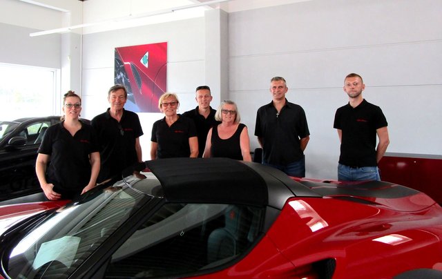 Andreas Gramsel (Mitte) stolz mit seinem Team vor einem nagelneuen Alfa Romeo 4C Spider 1750