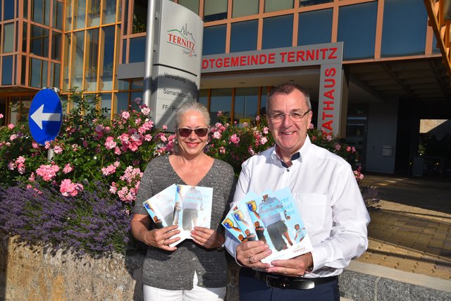 Stadträtin Andrea Reisenbauer und Bürgermeister Rupert Dworak präsentieren den aktuellen Ferienspielfolder.