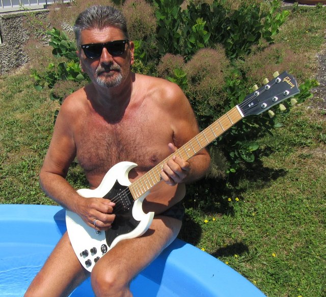 Georg Ragyozcy weiß wie man Arbeit und Spaß bei der aktuellen Hitzewelle am Besten verbindet: Gitarre spielen im Pool......