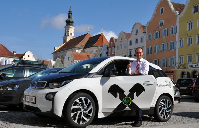 Direktor Rudolf Bauer mit dem i3 Elektroauto, das Mitarbeitern zur Verfügung steht – Ein "Fall" für den Regionalitätspreis.